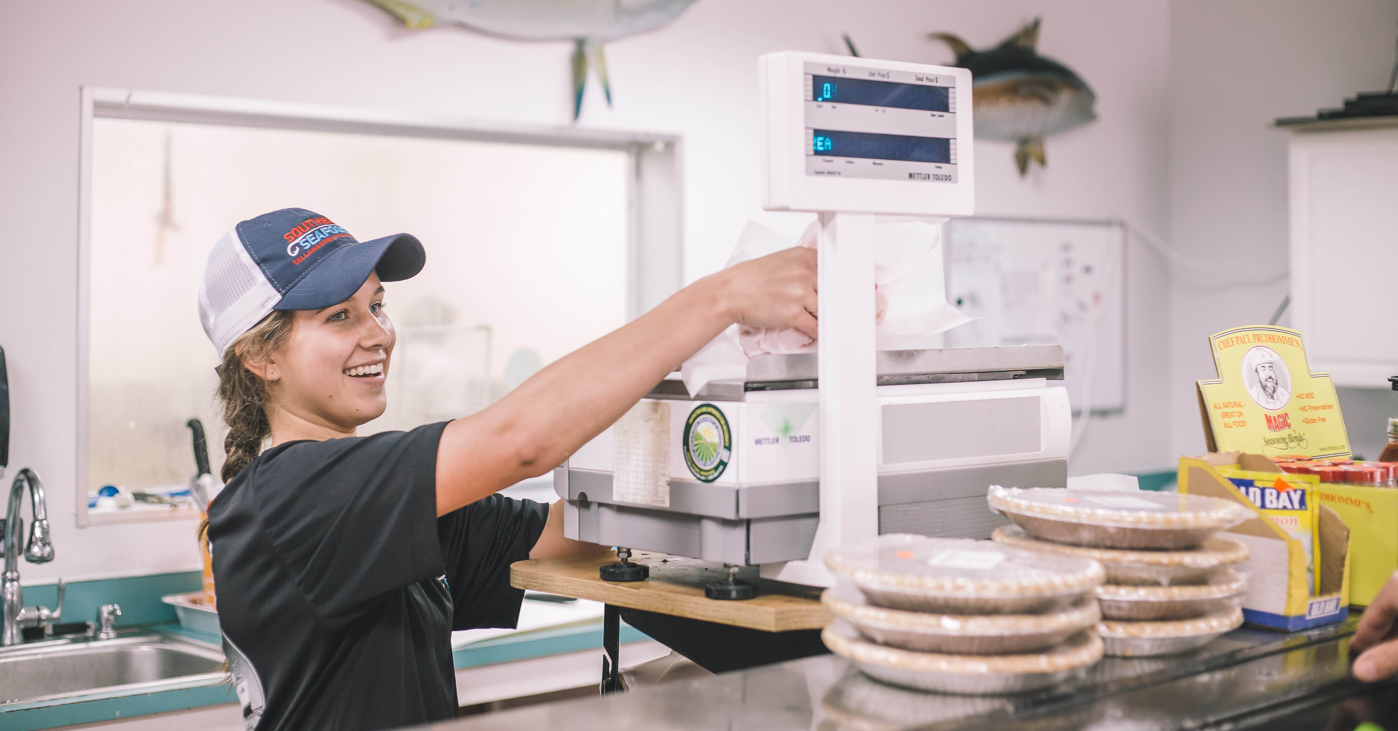 woman weighing seafood on a scale.